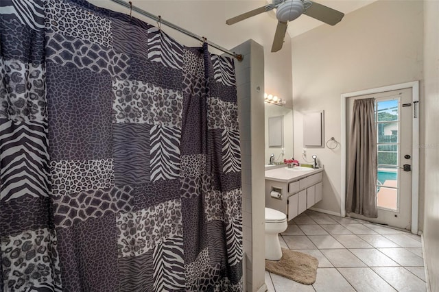 bathroom featuring toilet, tile patterned flooring, vanity, curtained shower, and ceiling fan