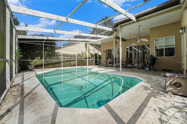 view of swimming pool featuring ceiling fan, a lanai, and a patio area