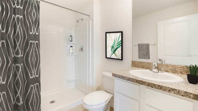 full bath featuring a stall shower, vanity, and toilet