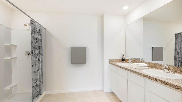 bathroom featuring double vanity, tile patterned flooring, walk in shower, and a sink