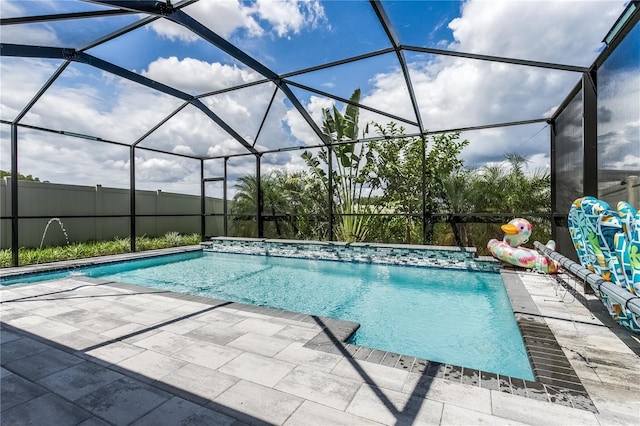 view of swimming pool with pool water feature, a patio area, and glass enclosure