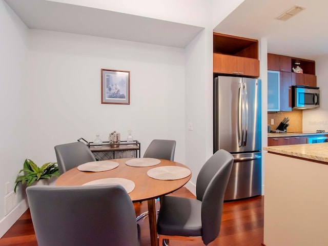 dining space with dark hardwood / wood-style flooring