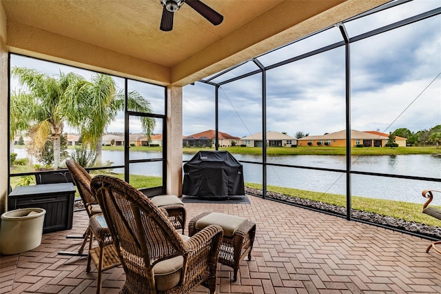 sunroom / solarium with a water view and ceiling fan