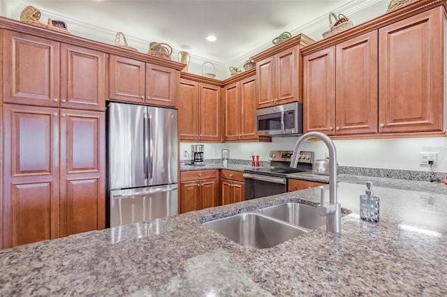 kitchen featuring light stone countertops, stainless steel appliances, crown molding, and sink