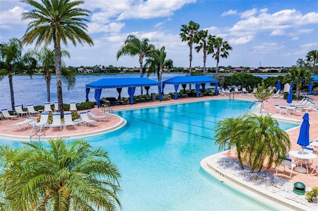 view of pool featuring a water view and a patio