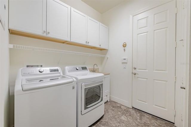 laundry area featuring washer and dryer, cabinets, and sink