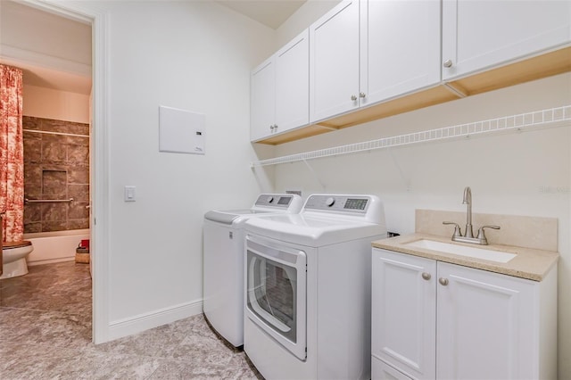 laundry area with cabinets, light tile patterned floors, separate washer and dryer, and sink