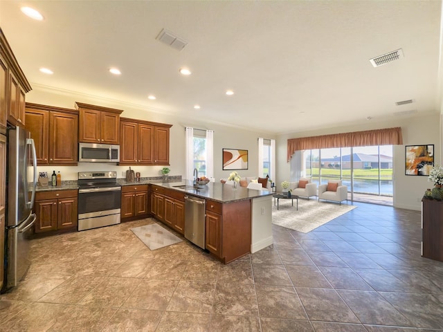 kitchen featuring kitchen peninsula, dark stone counters, stainless steel appliances, crown molding, and sink