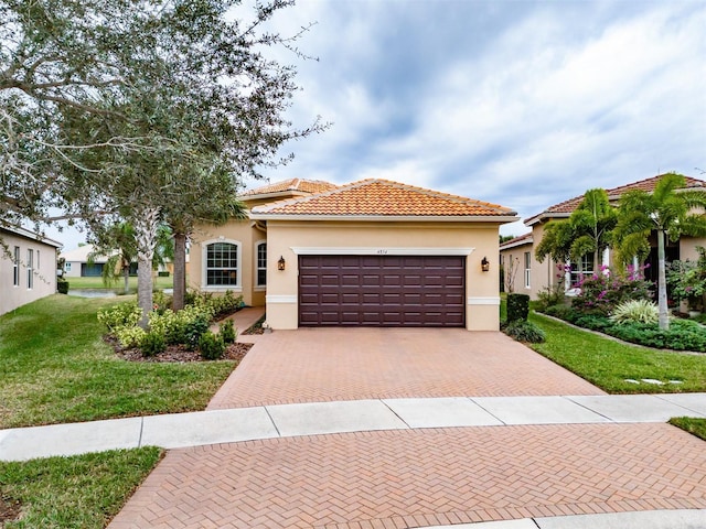 mediterranean / spanish-style home with a front lawn and a garage