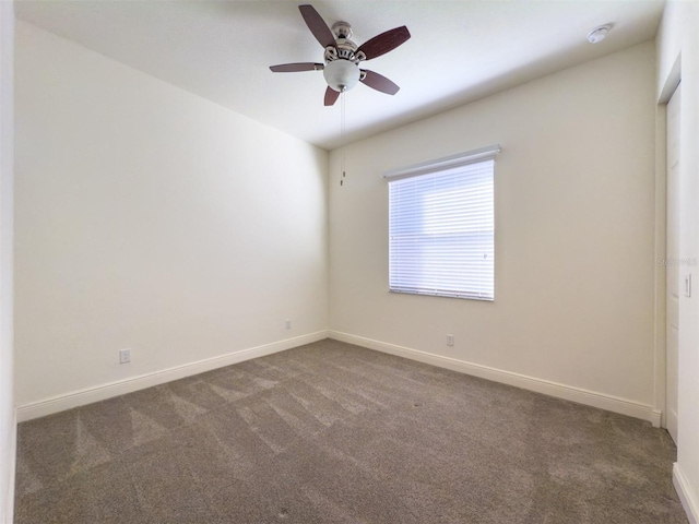 carpeted spare room featuring ceiling fan