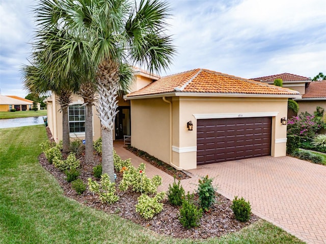 mediterranean / spanish home featuring a garage and a front yard