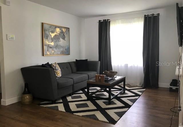 living room featuring plenty of natural light and dark wood-type flooring