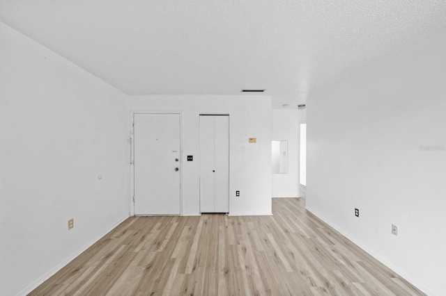 unfurnished bedroom with a textured ceiling and light hardwood / wood-style flooring