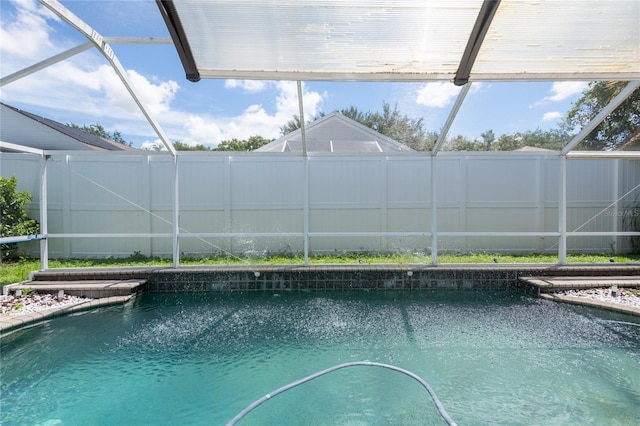 view of pool featuring glass enclosure