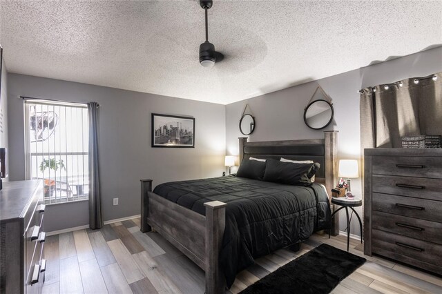 bedroom featuring ceiling fan, a textured ceiling, and light hardwood / wood-style flooring