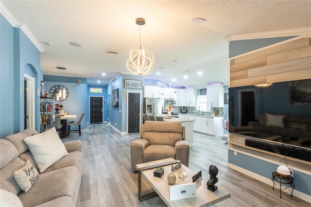 living room featuring light wood-type flooring, vaulted ceiling, a textured ceiling, and sink