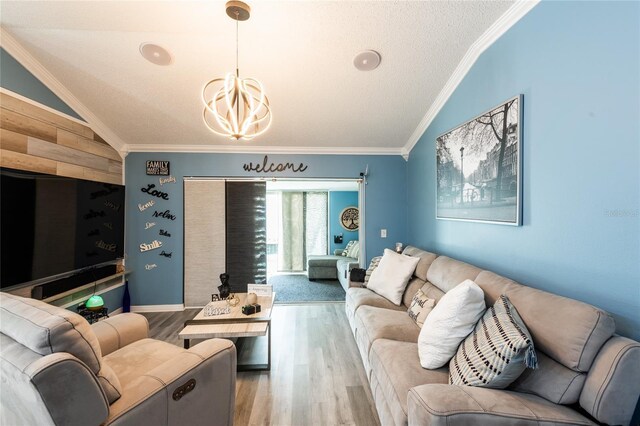 living room featuring ornamental molding, vaulted ceiling, a textured ceiling, and hardwood / wood-style flooring