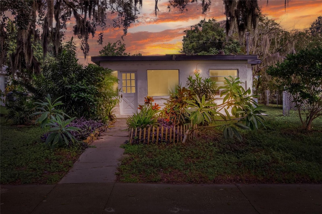 view of front of home featuring stucco siding and a lawn