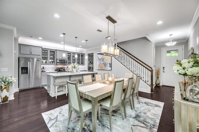 dining space featuring ornamental molding and dark hardwood / wood-style floors