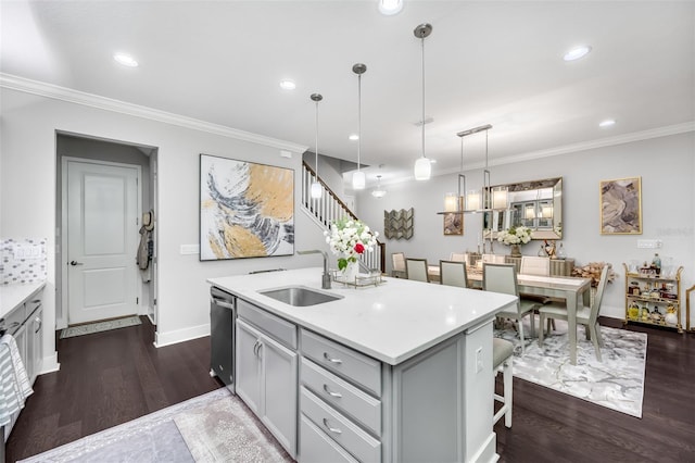 kitchen with decorative light fixtures, dark hardwood / wood-style flooring, sink, ornamental molding, and stainless steel dishwasher