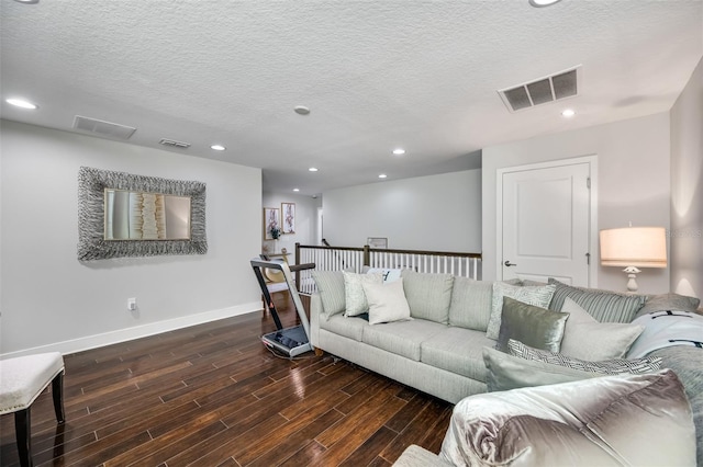 living room featuring dark hardwood / wood-style flooring and a textured ceiling