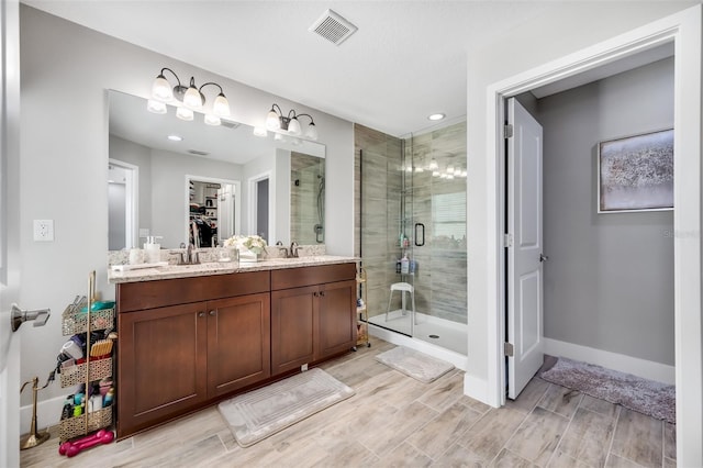 bathroom with vanity and a shower with door