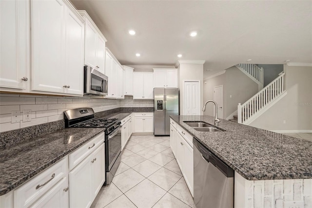 kitchen with white cabinets, appliances with stainless steel finishes, decorative backsplash, and sink