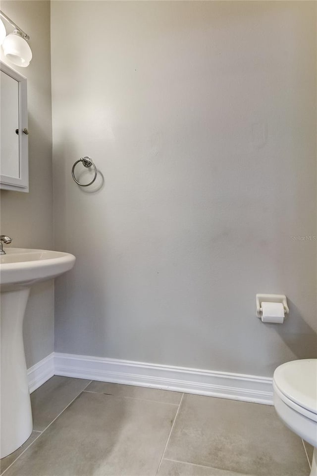 bathroom featuring tile patterned floors, toilet, and sink