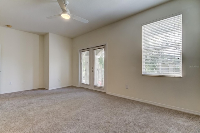 carpeted empty room featuring ceiling fan and french doors