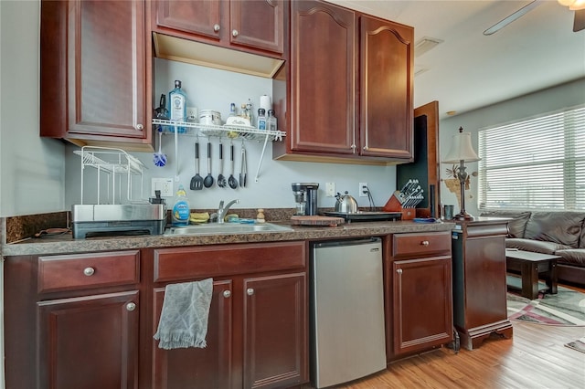 kitchen featuring light wood-type flooring, stainless steel fridge, sink, and ceiling fan