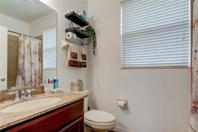 bathroom featuring curtained shower, toilet, and vanity