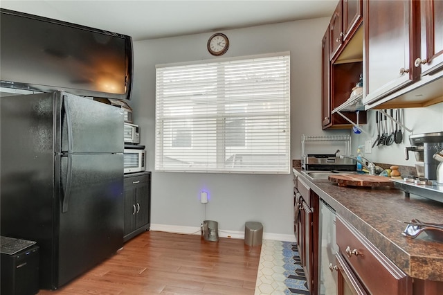 kitchen featuring light hardwood / wood-style floors, sink, and black fridge