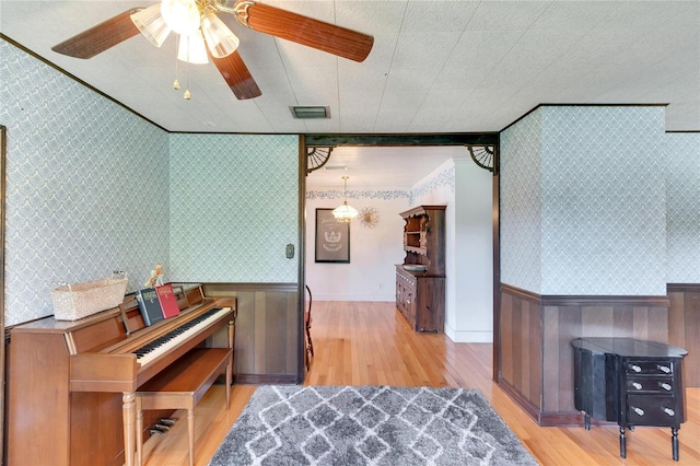 interior space with crown molding, light hardwood / wood-style flooring, and ceiling fan