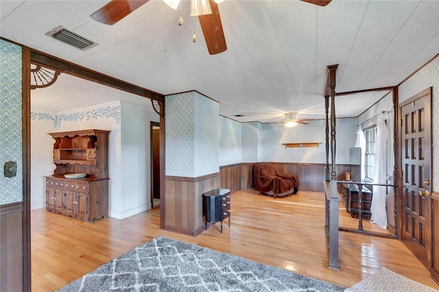 interior space with ornamental molding, light hardwood / wood-style flooring, and ceiling fan