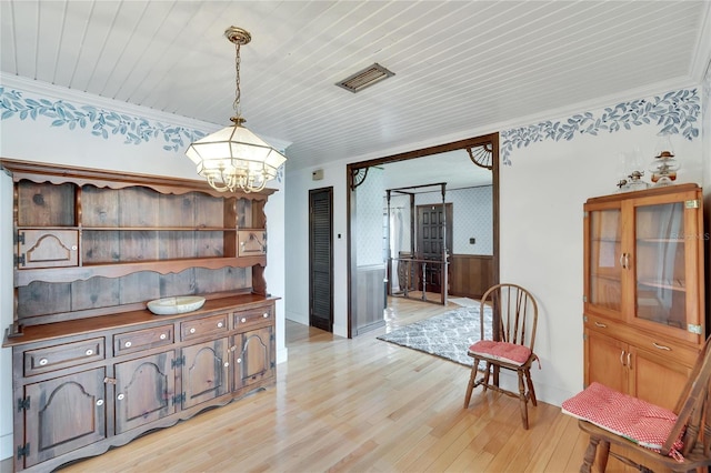 dining space featuring ornamental molding, wood ceiling, a chandelier, and light hardwood / wood-style floors