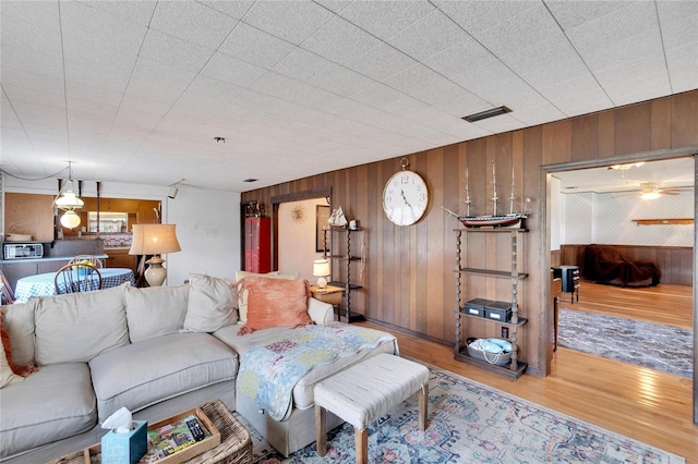 living room with hardwood / wood-style floors and wood walls