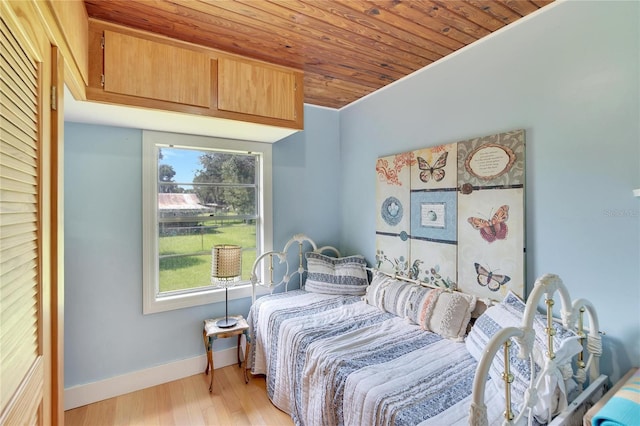 bedroom with wooden ceiling and light hardwood / wood-style floors