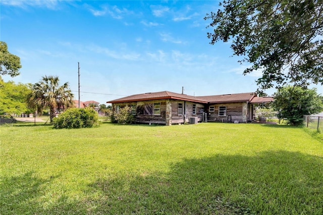 back of property with a lawn and central air condition unit