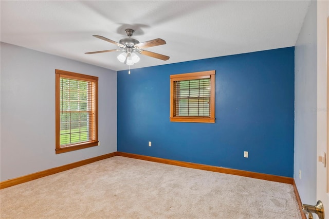 carpeted spare room with ceiling fan