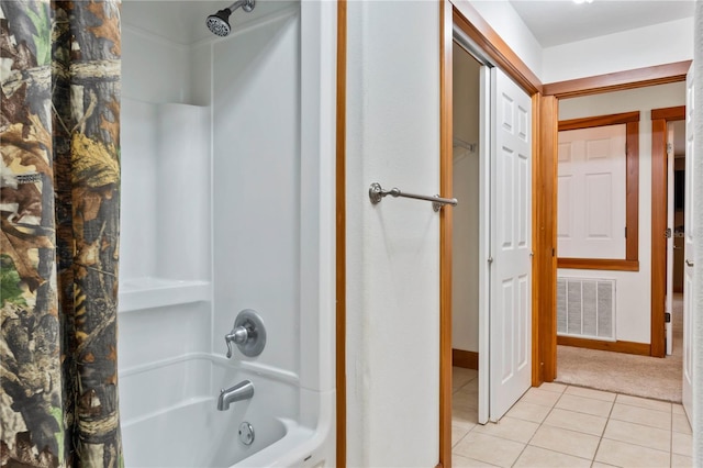 bathroom featuring tile patterned flooring and  shower combination