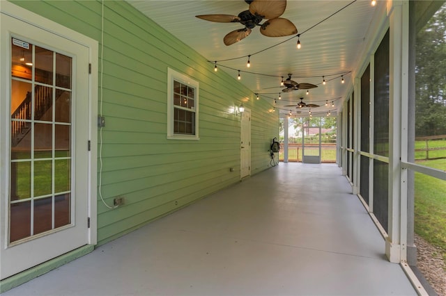 unfurnished sunroom with ceiling fan