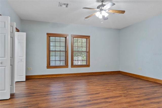 spare room featuring ceiling fan and dark wood-type flooring