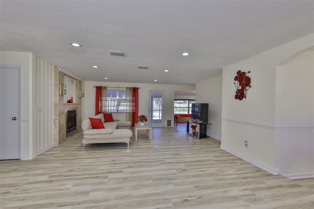 living room with a textured ceiling and light hardwood / wood-style flooring