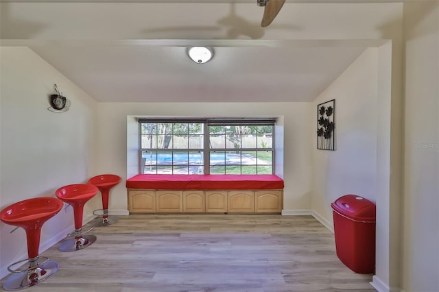 living area with vaulted ceiling, ceiling fan, and light hardwood / wood-style floors