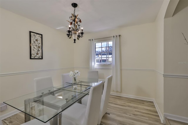 dining area featuring light hardwood / wood-style flooring and a chandelier