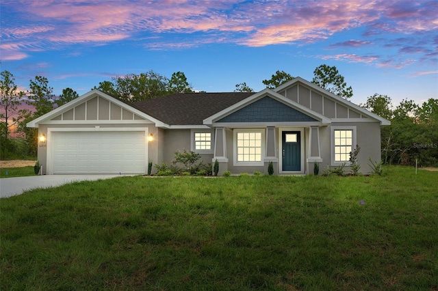 view of front of property featuring a garage and a lawn