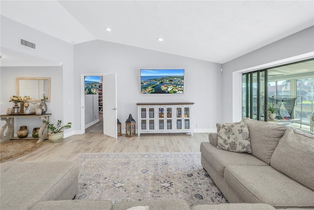 living room featuring lofted ceiling and light hardwood / wood-style flooring