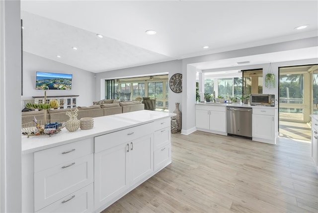 kitchen featuring light hardwood / wood-style flooring, stainless steel appliances, sink, lofted ceiling, and white cabinets