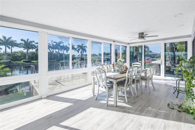 sunroom / solarium featuring a water view, ceiling fan, and plenty of natural light