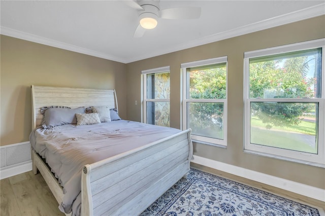 bedroom with crown molding, hardwood / wood-style floors, and ceiling fan